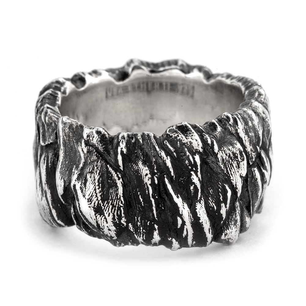 Front angle of Ether Eleven's Stone Cliff Band, layered rock-like ledges cut across the sterling silver.