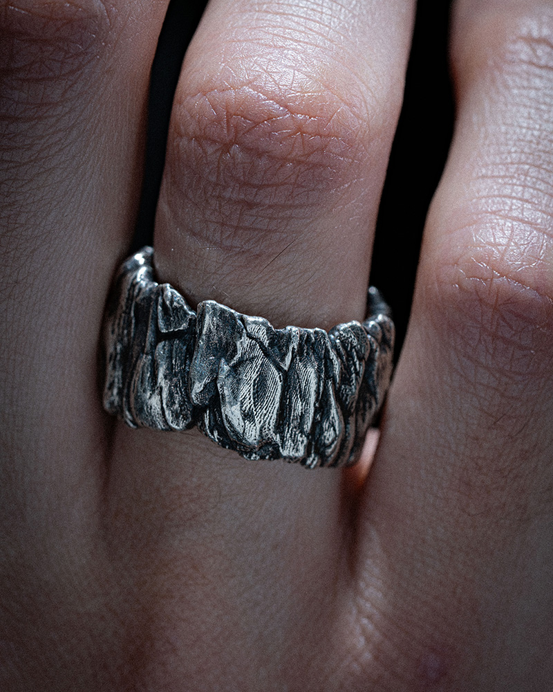 Stone Cliff Band worn on a hand, a rugged carved silver band with an eroded stone look.