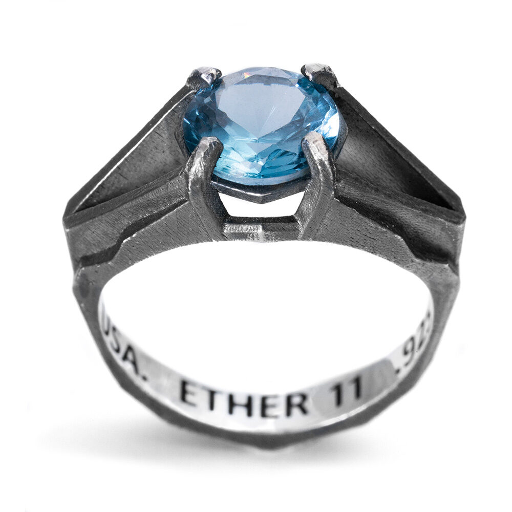 The Antimatter Ring, an architectural alternative wedding band in oxidized sterling silver set with a custom-cut nano Paraiba tourmaline, by Ether Eleven.