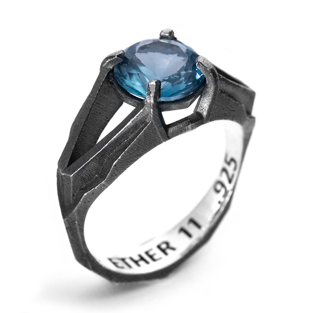 The Antimatter Ring from the opposite angle, showing the sharp brutalist facets of the oxidized sterling silver band.