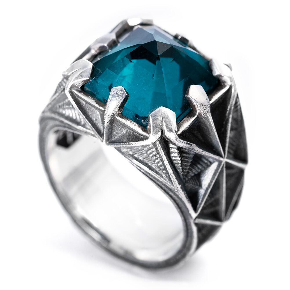 Angled view of the Arrival Ring showing the starburst-carved shoulders of the oxidized sterling silver band.