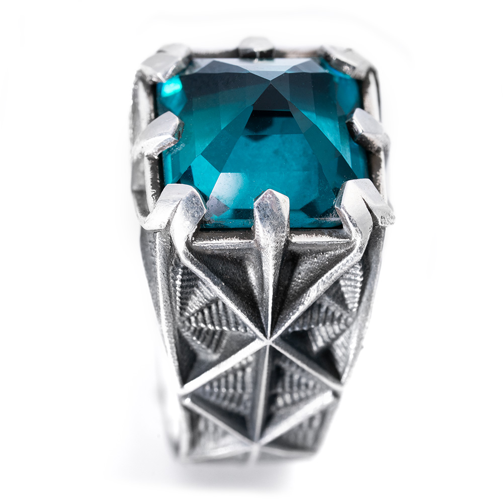 Top-down view of the Arrival Ring's 13mm Paraiba tourmaline held in six sculpted silver prongs.