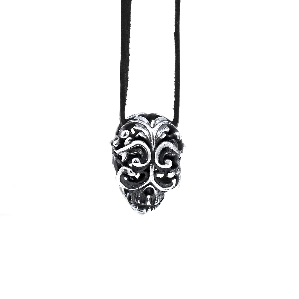 Filigree Skull Pendant — hero The Filigree Skull Pendant in sterling silver, its domed skull carved with scrolling filigree, hung on a black leather cord by Ether Eleven.
