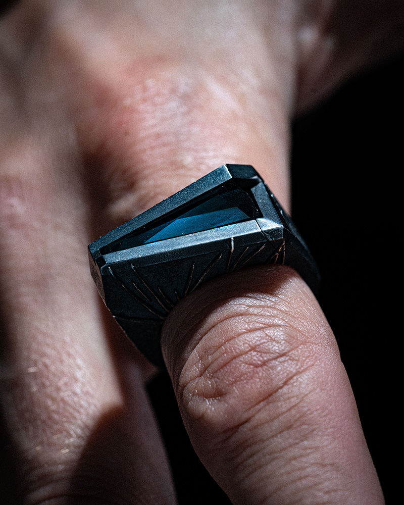 The Momentum Ring worn on the finger, showing how the wedge-shaped silver face sits across the hand.