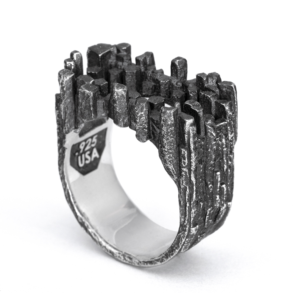 Stone Tower Frame Ring — hero The Stone Tower Frame Ring in oxidized sterling silver, its hollow frame cast as clustered basalt columns, from the Ether Eleven Terra collection.