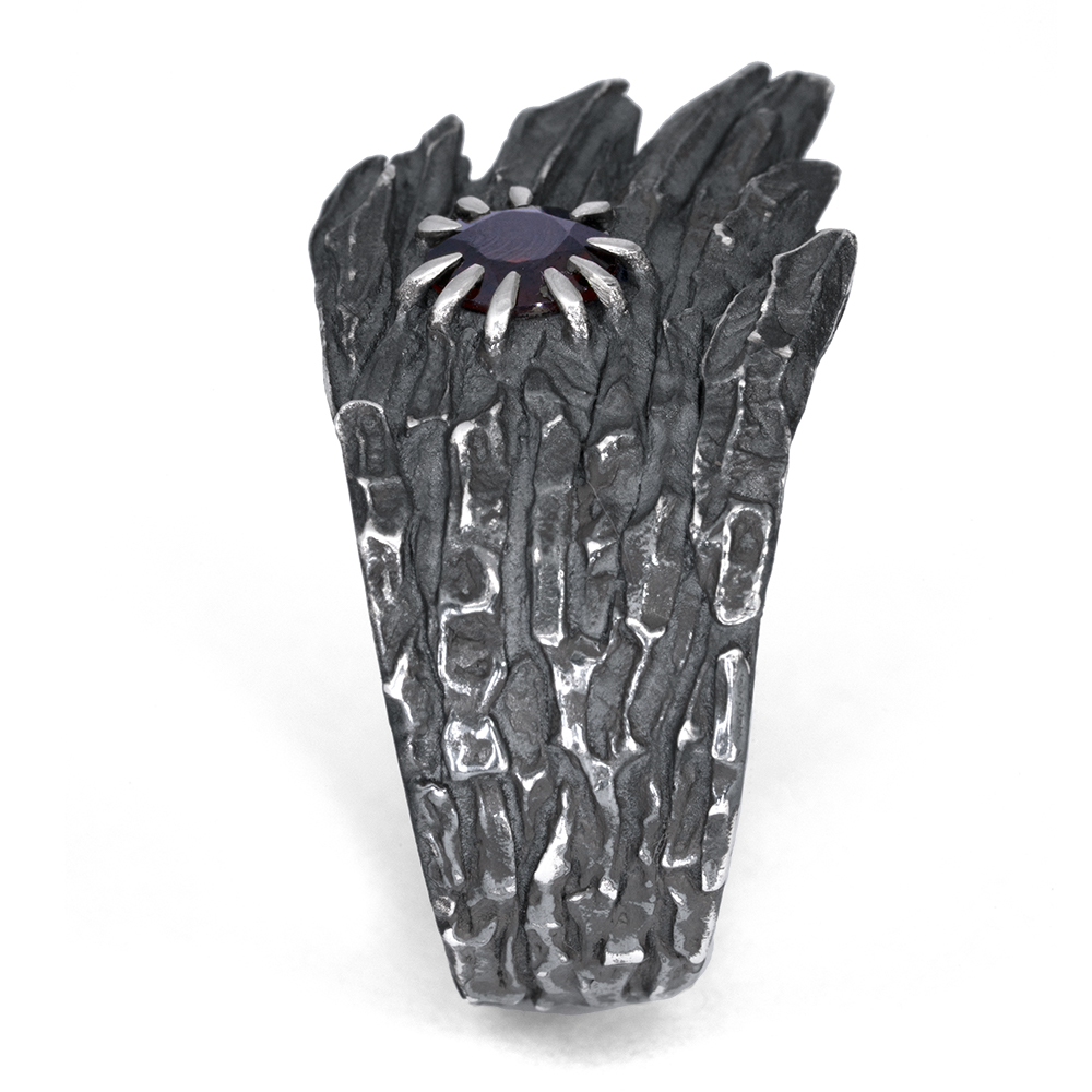 Top-down view of the Stone Wing Ring showing the deep red garnet and the eroded canyon texture of the oxidized silver.